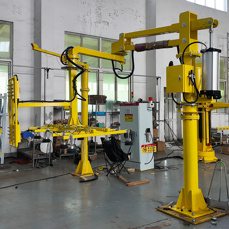 Yellow column-mounted vacuum lifting manipulator with articulated arm and suction cup gripper in a manufacturing facility